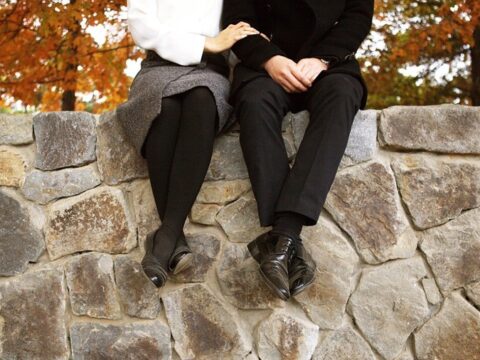 Man and Woman Sitting on a Garden Wall