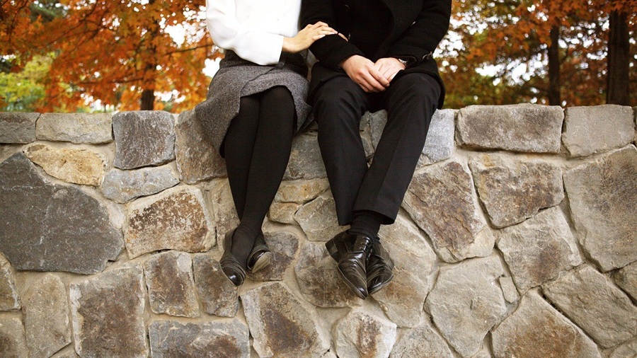 Man and Woman Sitting on a Garden Wall